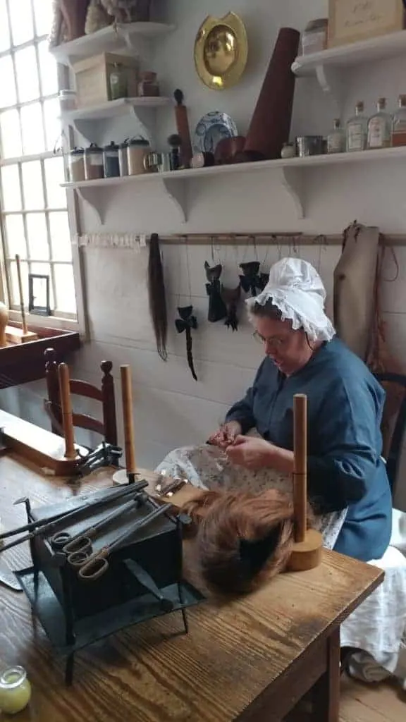 Colonial Williamsburg: a living history re-enactor making a wig