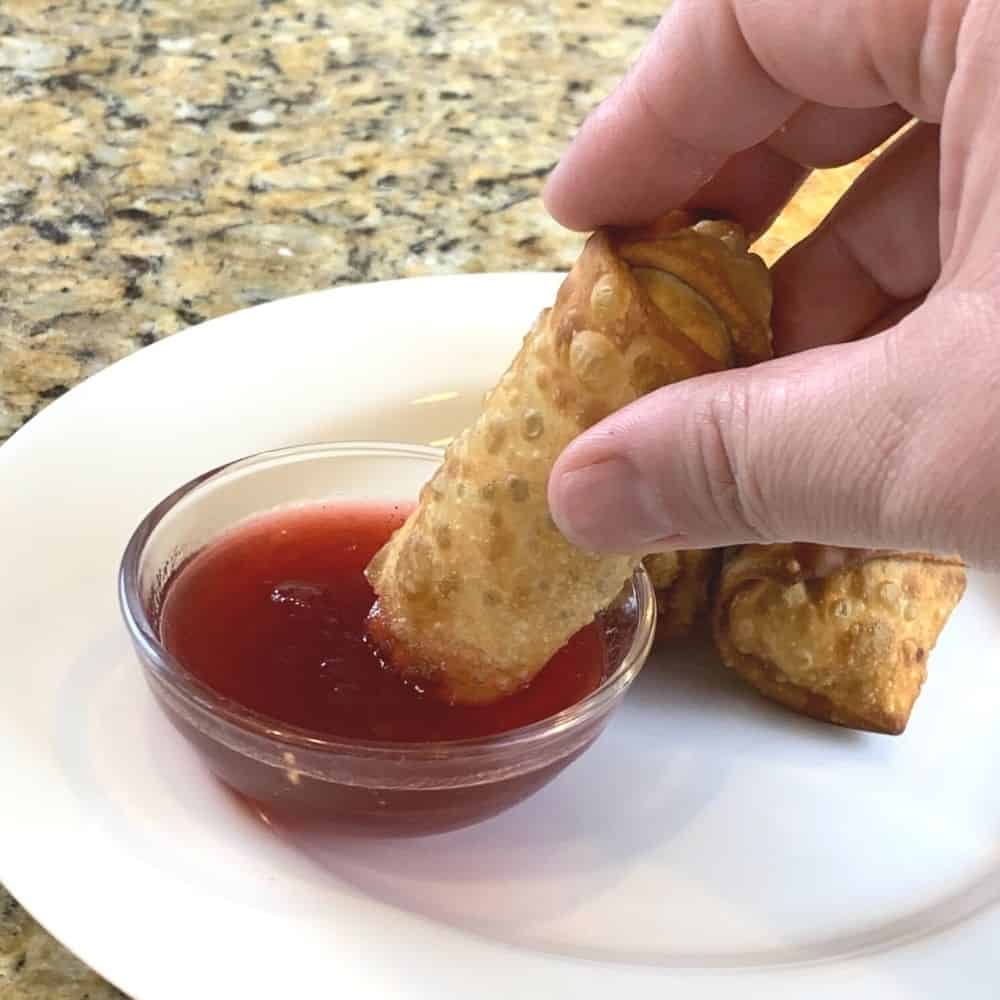 dipping leftover egg rolls into cranberry sweet and sour sauce