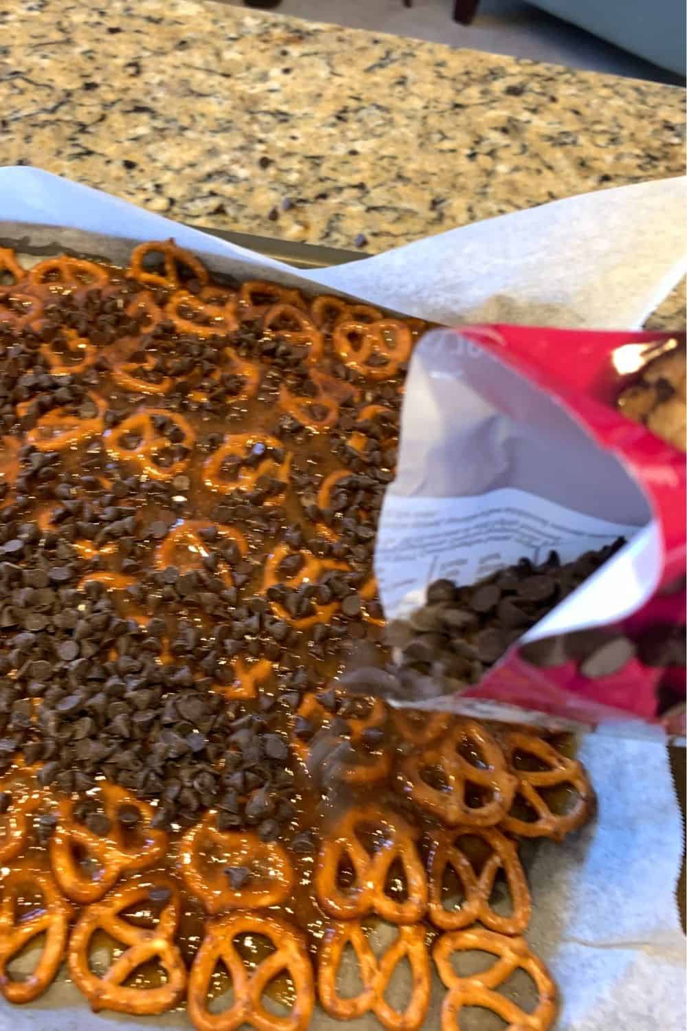 adding chocolate chips to the pretzel toffee bark