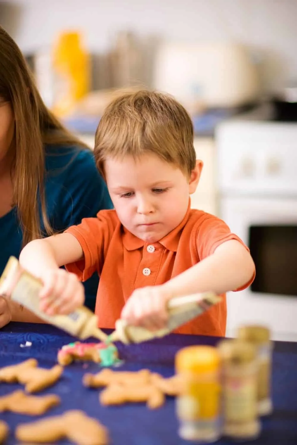 little boy decorating holiday cookies