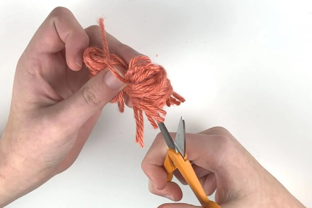 Cut the loops to create the pom pom