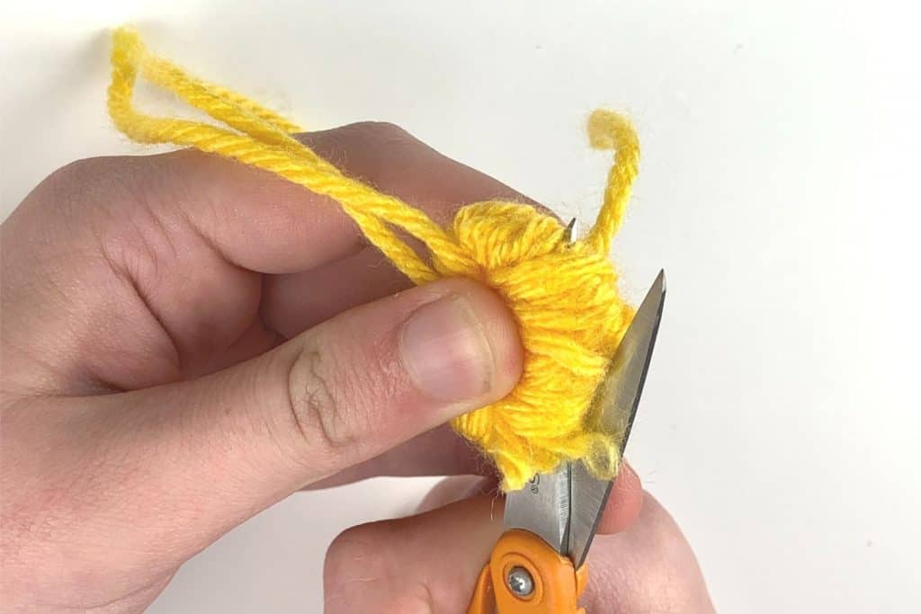 Trimming the loops to form the pom-pom