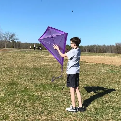 Kid holding a diamond kite