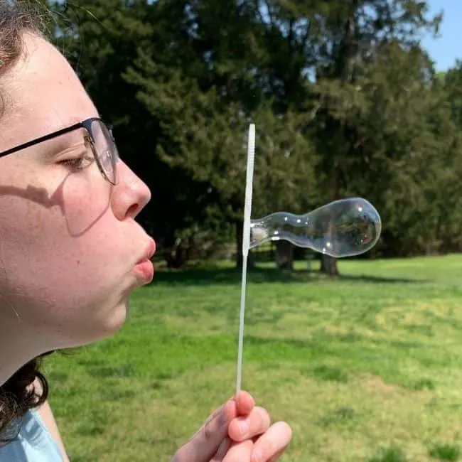 girl blowing a bubble from homemade bubble solution