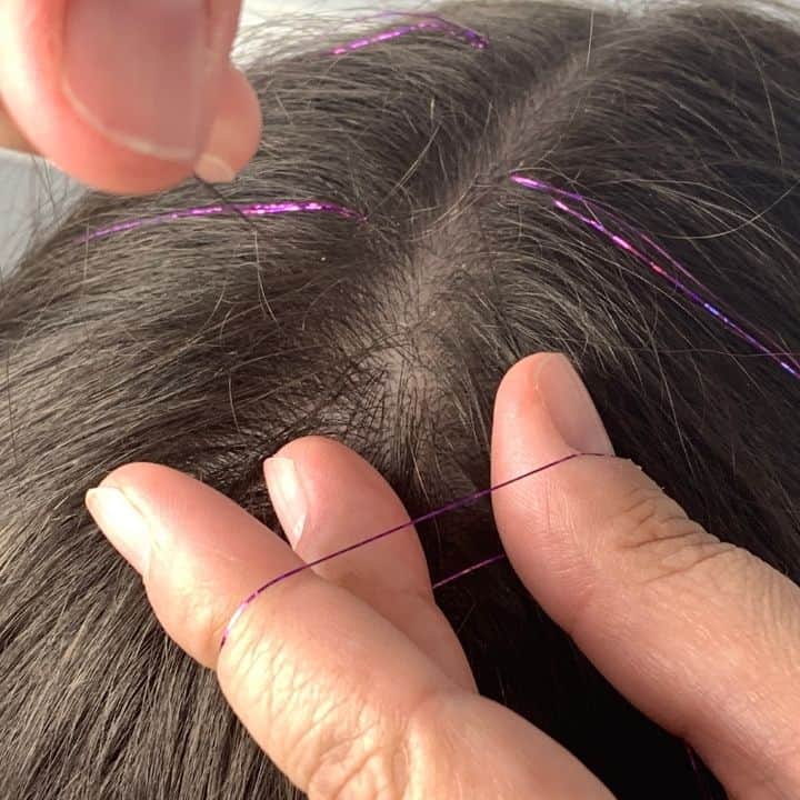 adding hair tinsel to a strand of hair