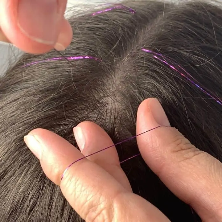 adding hair tinsel to a strand of hair