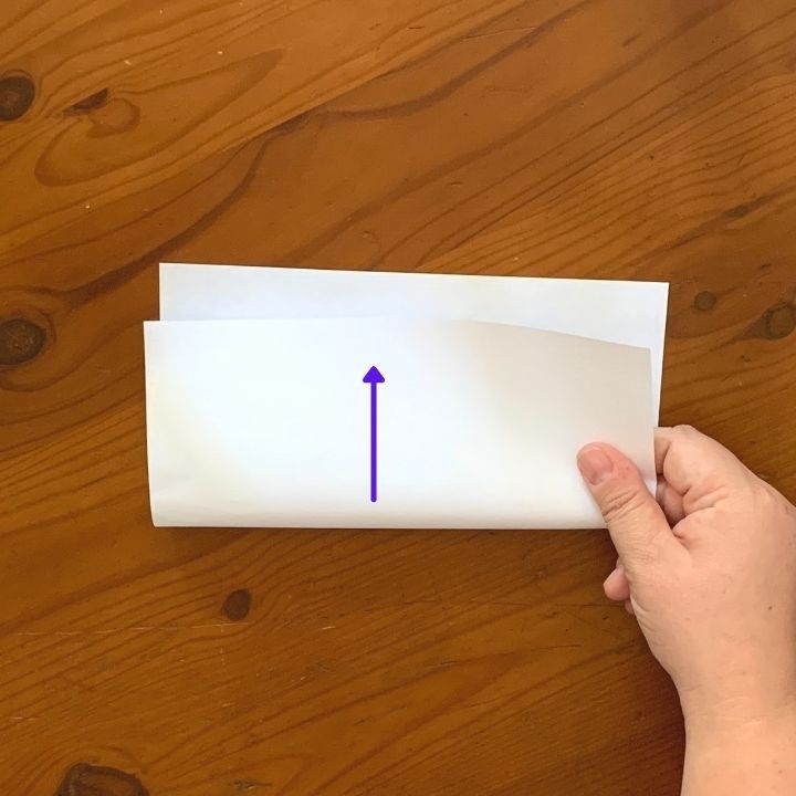 Paper folded in half for the first step of an origami star